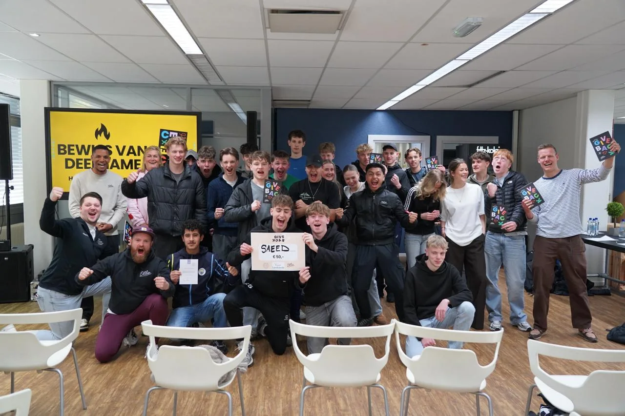 Een groep studenten en trainers van Ollie juicht na de Give Back Day bij Landstede