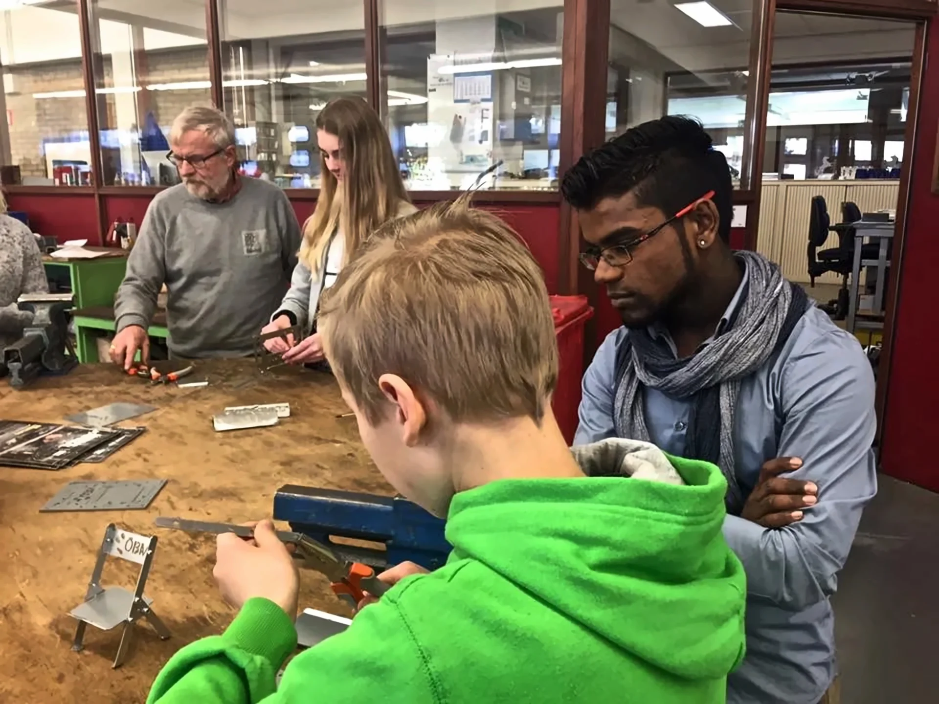 Ambassadeur van Technova College helpt een leerling tijdens een workshop in de werkplaats