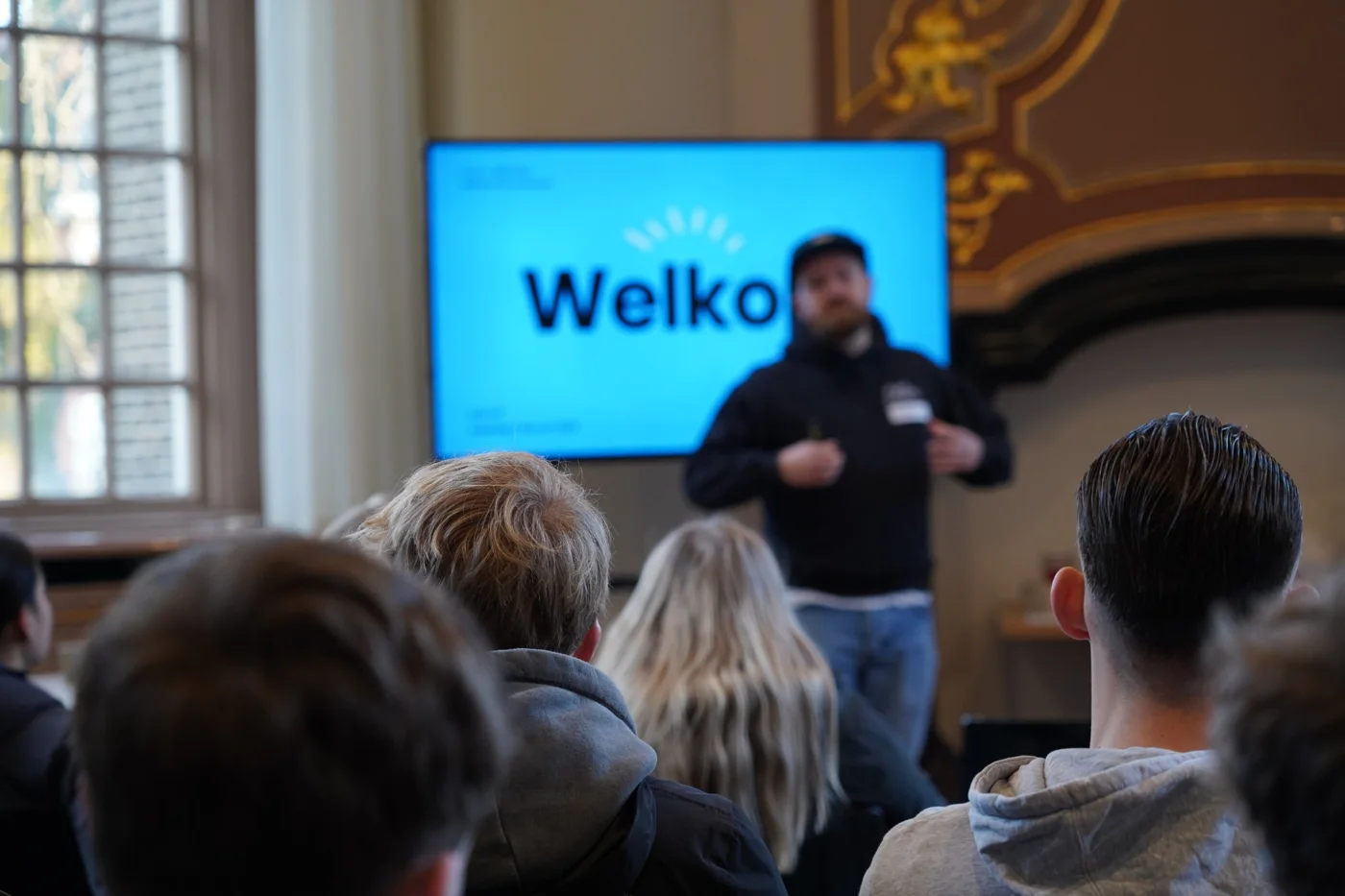 Trainer van Ollie heet een groep eerstejaars welkom