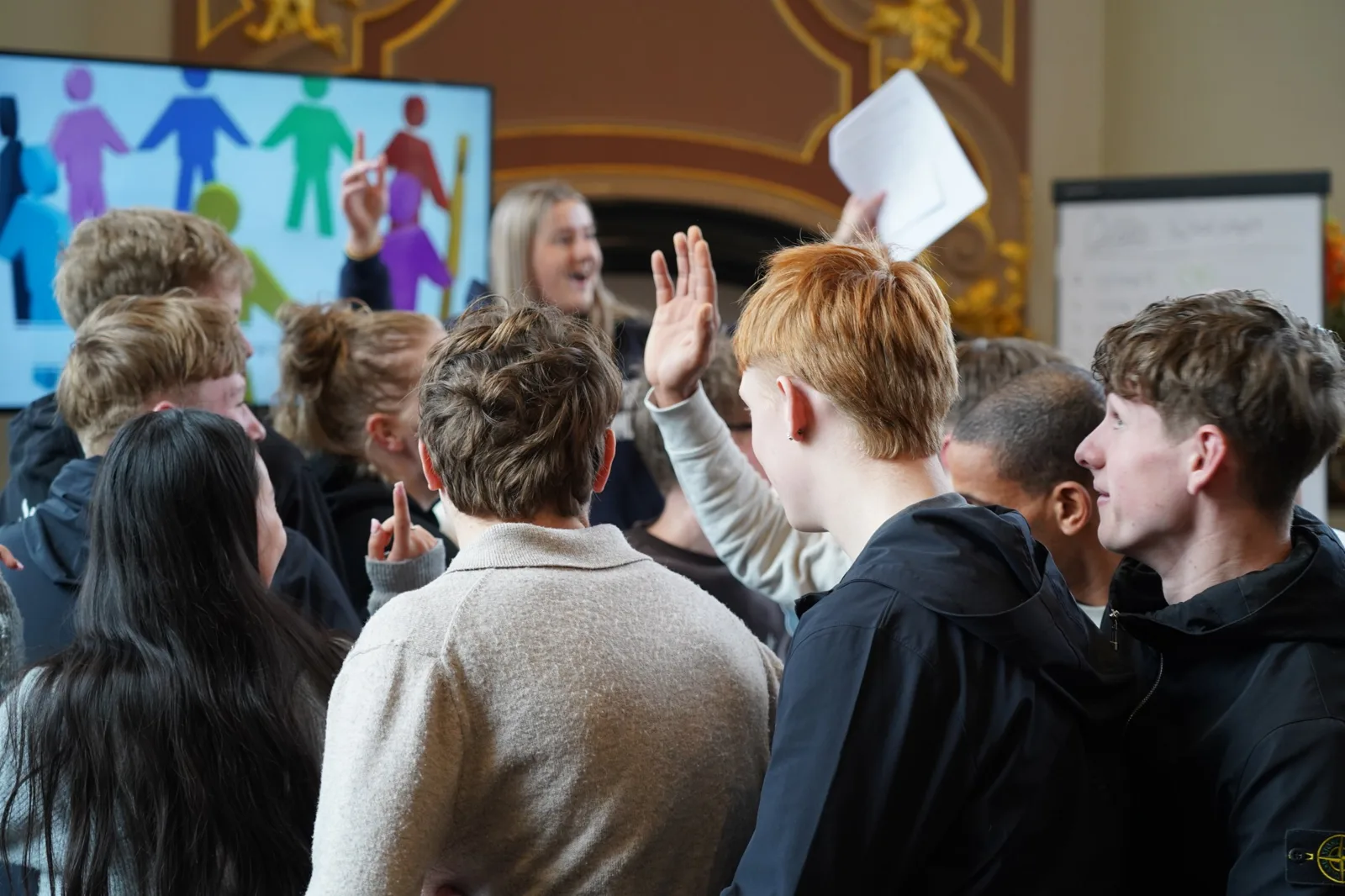 Studenten steken enthousiast hun hand op tijdens een les van Ollie