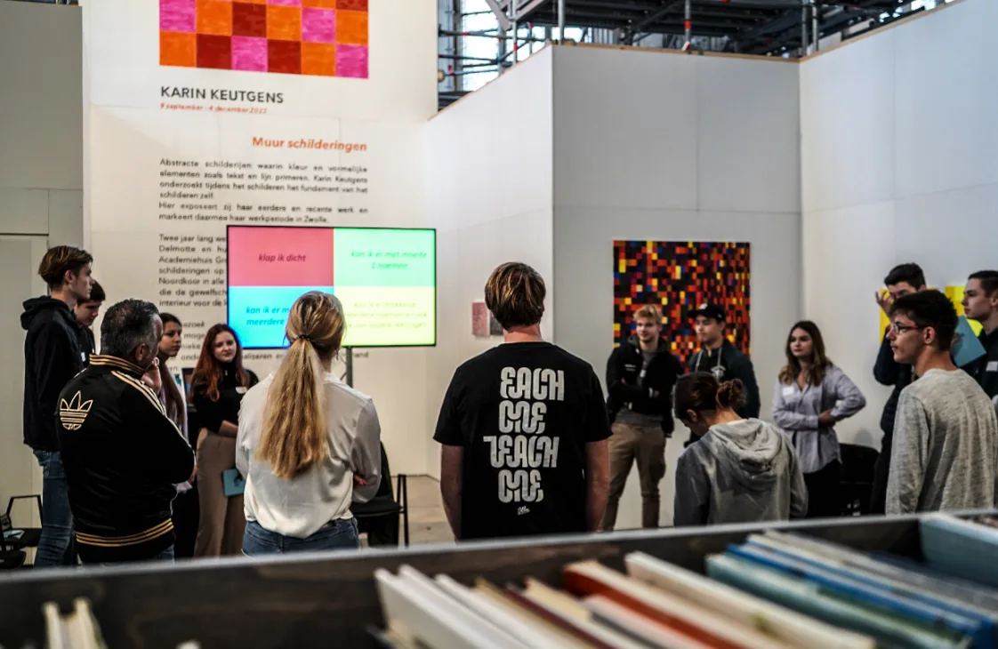 Groep studenten tijdens een training, een van hen draagt een shirt met Each one teach one